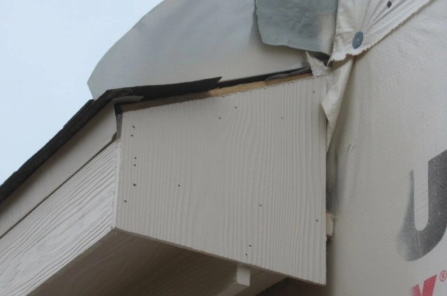 Close-up missing metal drip edge flashing and exposed roof decking at the lower roof edge of a new construction  home in Manvel, Texas, documented by home inspector Brad Leland