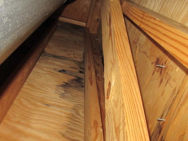 Discoloration on attic roof decking near the chimney chase.