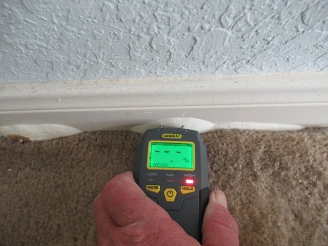 This condition of swollen baseboard was observed under several windows on the baseboard. The inspection showed high moisture.