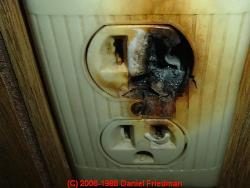 Heat-damaged electrical receptacle shown in the article about aluminum wiring.