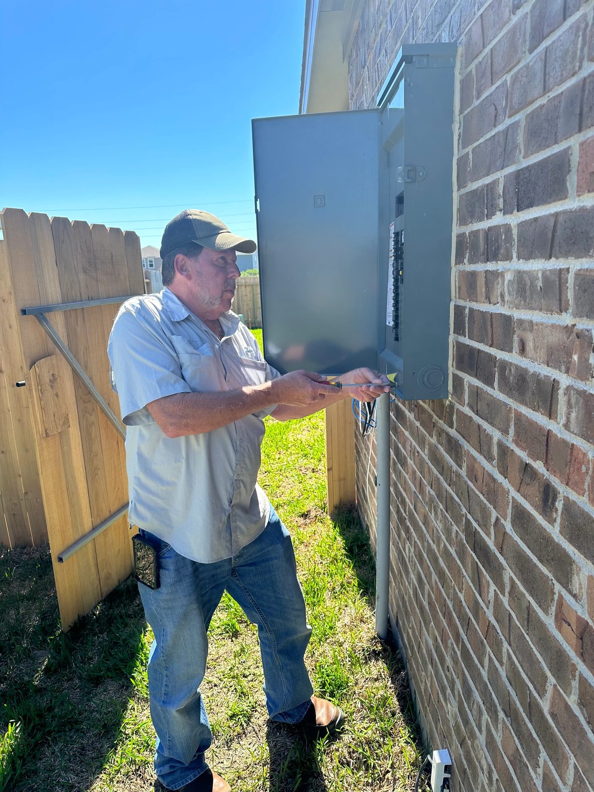 Brad opening an exterior electrical panel during a home inspection