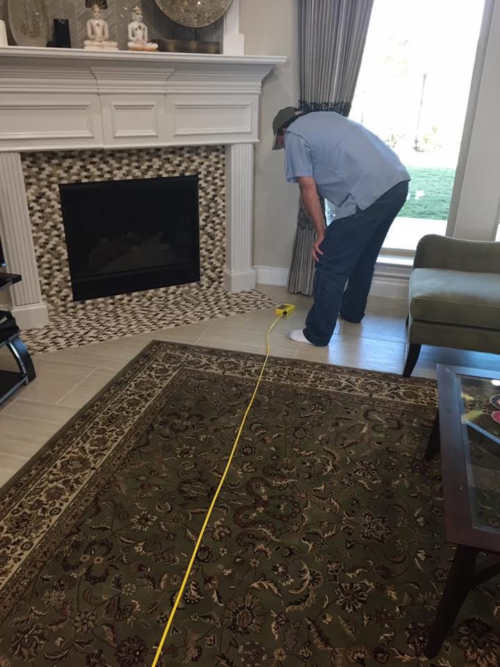 Brad Leland using ZipLevel equipment to measure foundation elevations inside an existing home