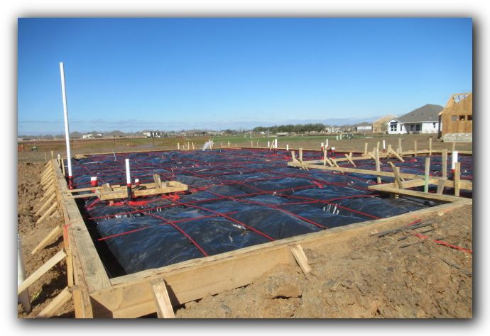 Overall foundation preparation before concrete placement, with forms, reinforcement and plumbing penetrations visible